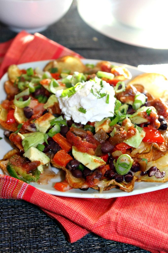 a close up view of nachos with beans and vegetables on a plate 