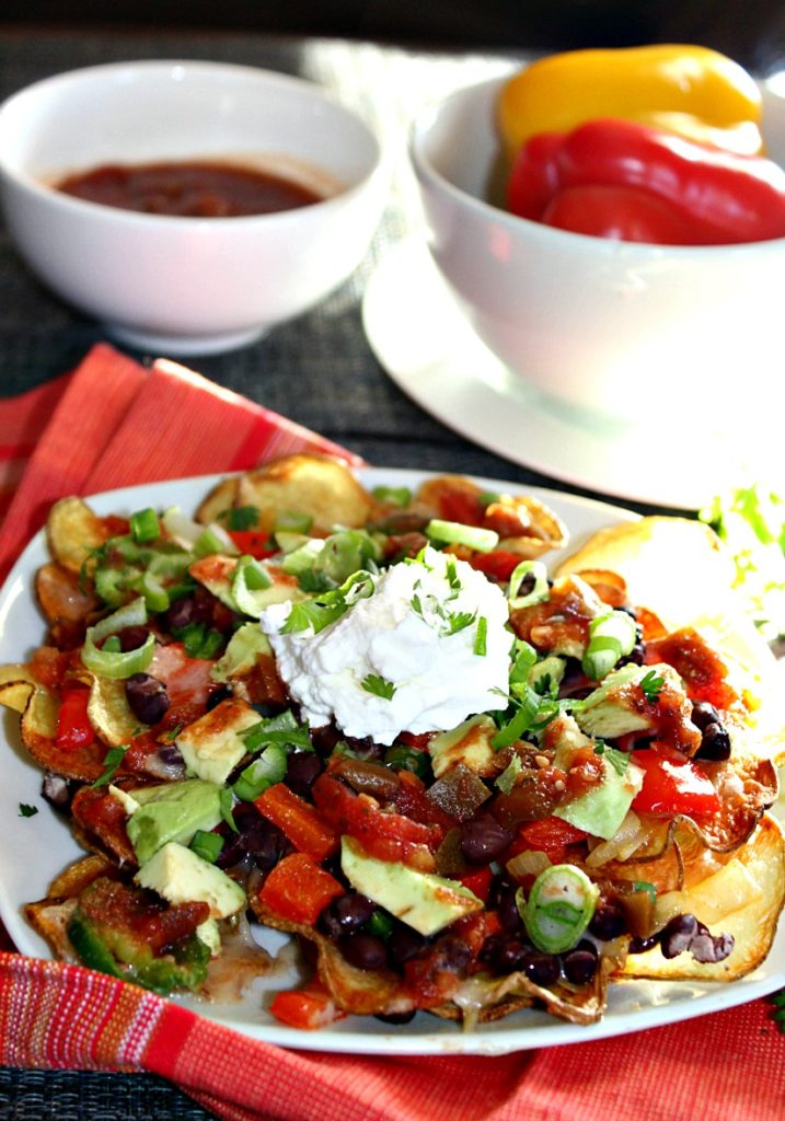 a plate of nach with a bowl of salsa in the background