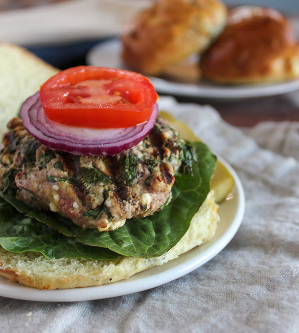 spinach and feta turkey burger on a roll with onions