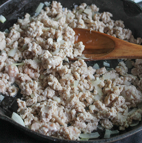 step one ground chicken cooking in a skillet