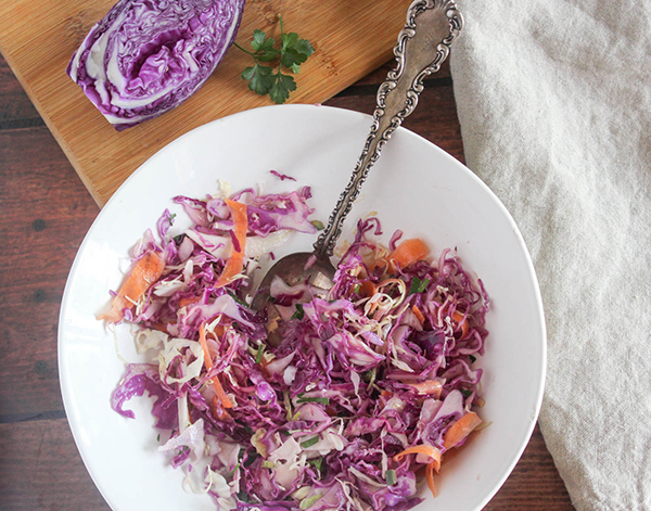 a view looking down into a bowl of coleslaw with a spoon