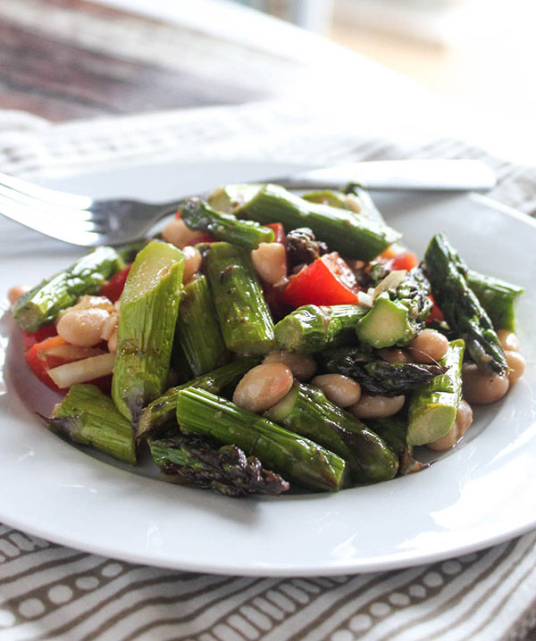 A close up view of grilled asparagus salad in a bowl