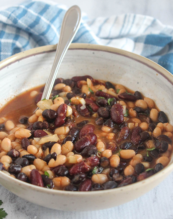 slow cooked baked beans in a bowl with a spoon