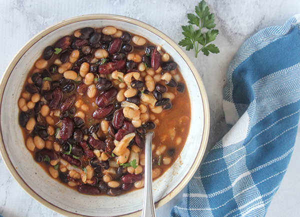 an overhead veiw of slow cooked beans in a bowl with a spoon