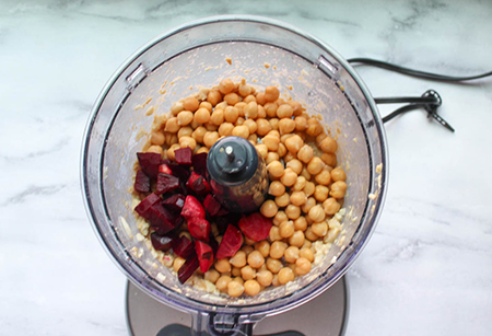 Beets and check peas in a food processor bowl