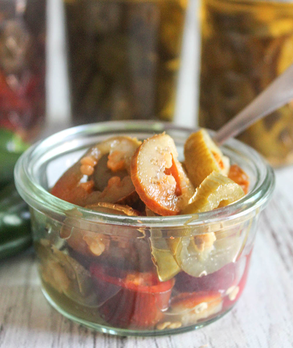 an open jar of pickled jalapenos with a spoon