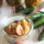 an open jar of pickled jalapeno peppers with a spoon