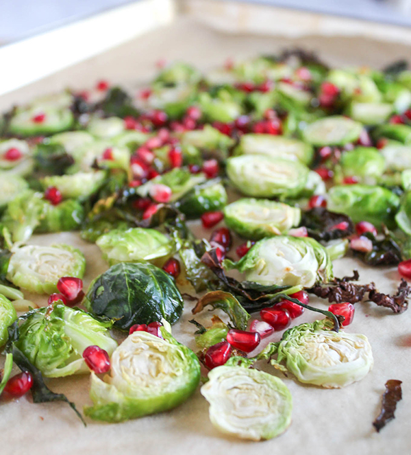 brussels sprouts and pomegranate arils on a baking sheet