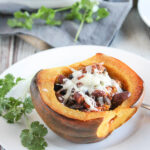 a half of an acorn squash stuffed with ground turkey and cheese