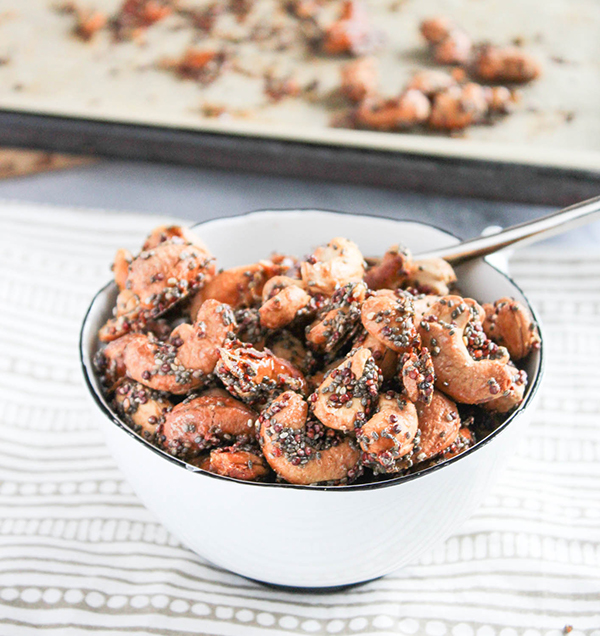 glazed cashews in a bowl with aspoon