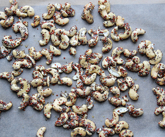 glazed cashews on a baking sheet ready for the oven