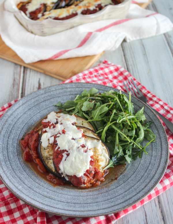 eggplant casserole on a plate with a red and white checkered napkin