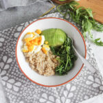 savory breakfast bowl filled with oats greens egg and avocado