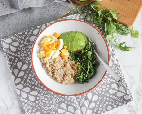 savory breakfast bowl filled with oats greens egg and avocado