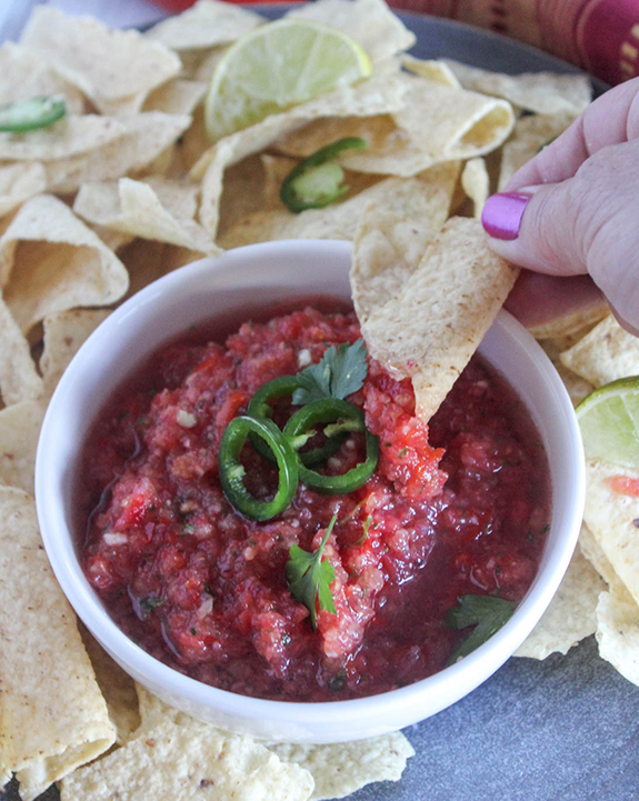 Salsa with a chip being dipped into it