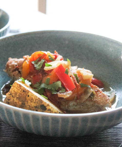 A close up of chicken, potatoes and vegetables in a bowl