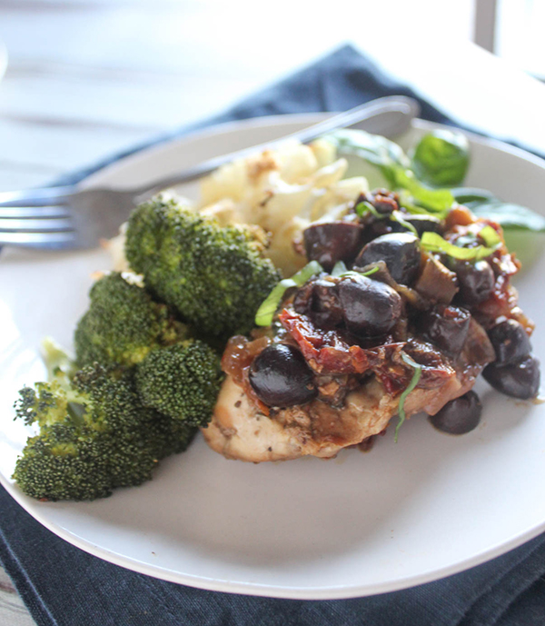 Mediterranean chicken on a plate with a fork on a napkin