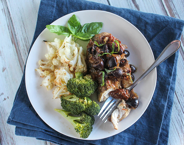 Mediterranean chicken on a plat with broccoli and cauliflower