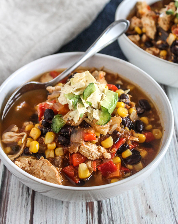 A bowl of chicken tortilla soup with a spoon