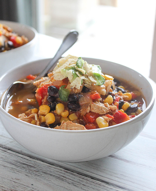 an up close view of chicken tortilla soup in a white bowl