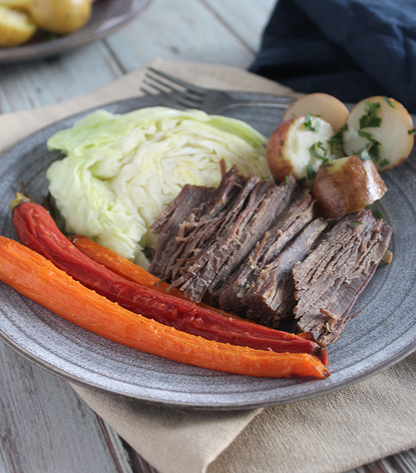 carrots corned beef cabbage and potatoes on a plate with a fork