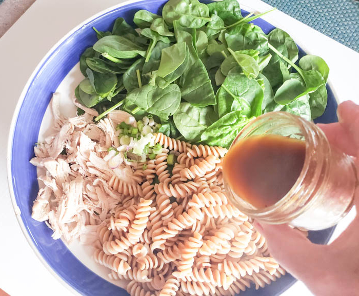 a photo of the dressing pouring over the salad