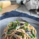 creamy pasta with vegetables on a plate with a fork