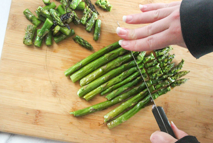 asparagus on a cutting board being cut