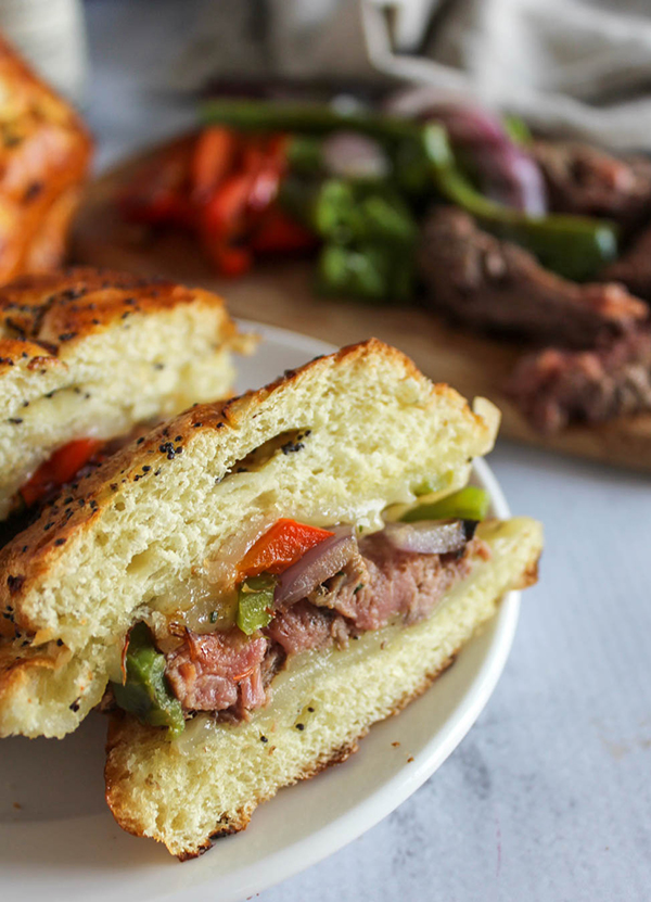 A picture of a beef filet mignon sandwich sliced in half on a plate