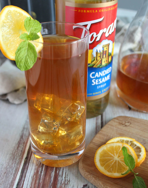 Sesame ginger iced tea in a glass with lemon slices