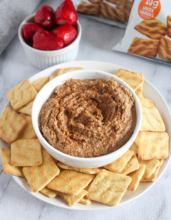 snickerdoodle hummus in a bowl with cornbread crisps and strawberries