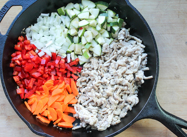 diced carrots peppers onions and zucchini in a pan