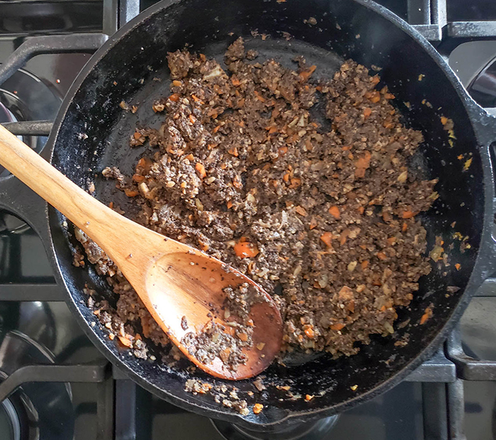 Processed veggie burger ingredients cooking in a skillet