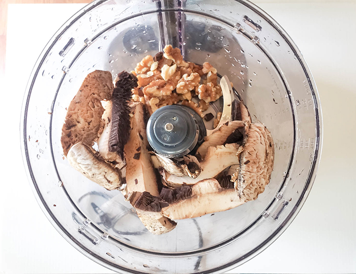 second step of making veggie burgers : mushrooms and walnuts in a bowl of food processor