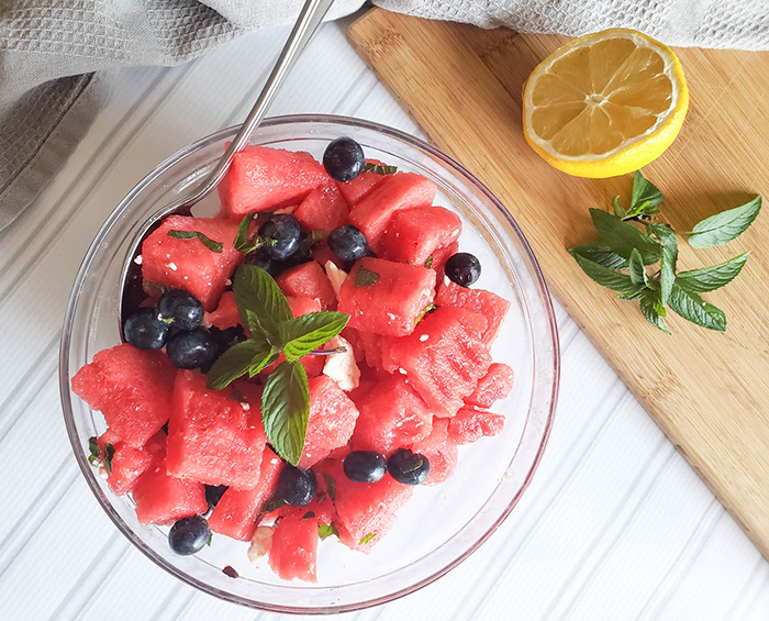 an overhead view of the finished red white and blue salad in a glass bowl