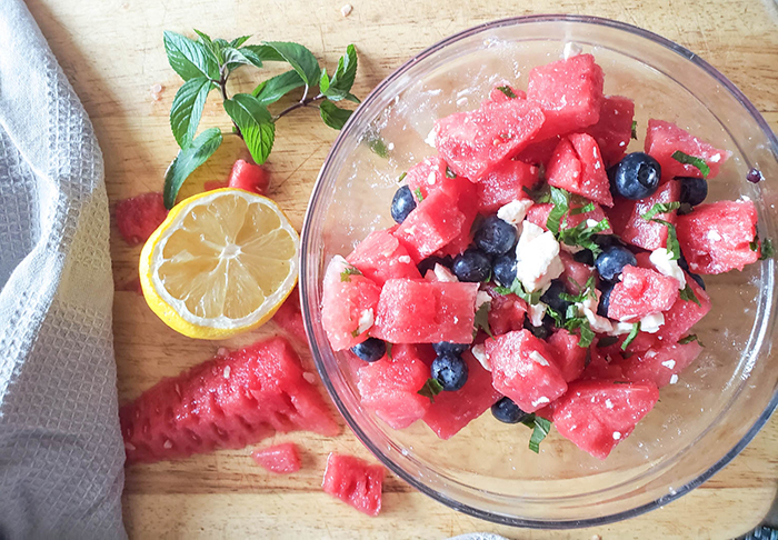 an overhead photo of the watermelon salad ingredients in a bowl mixed together