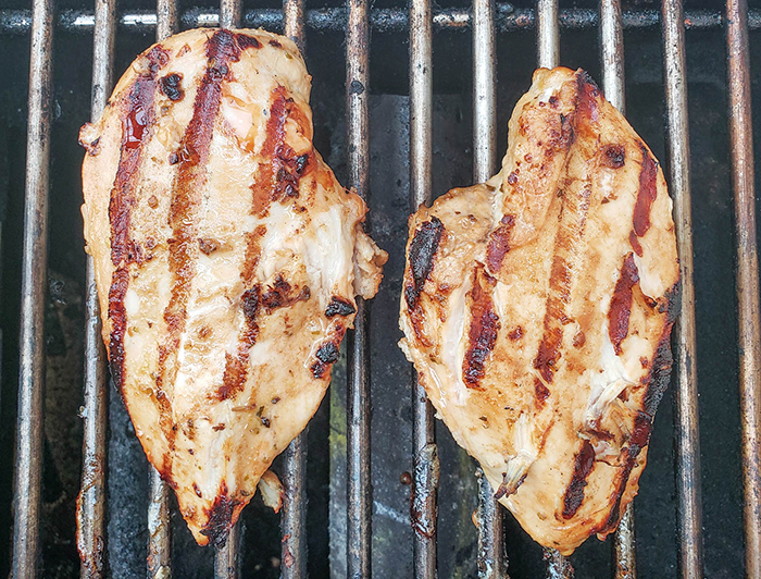 chicken breasts cooking on the grill