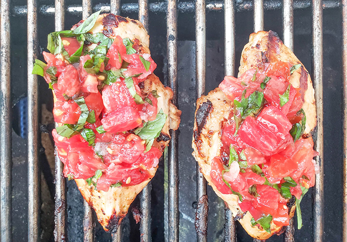 chicken breasts on grill with tomatoes