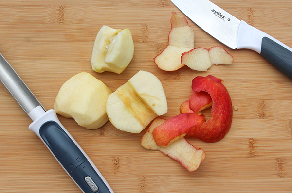 apples cut in half with a knife on a board