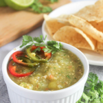 salsa verde in a bowl with chips on a plate