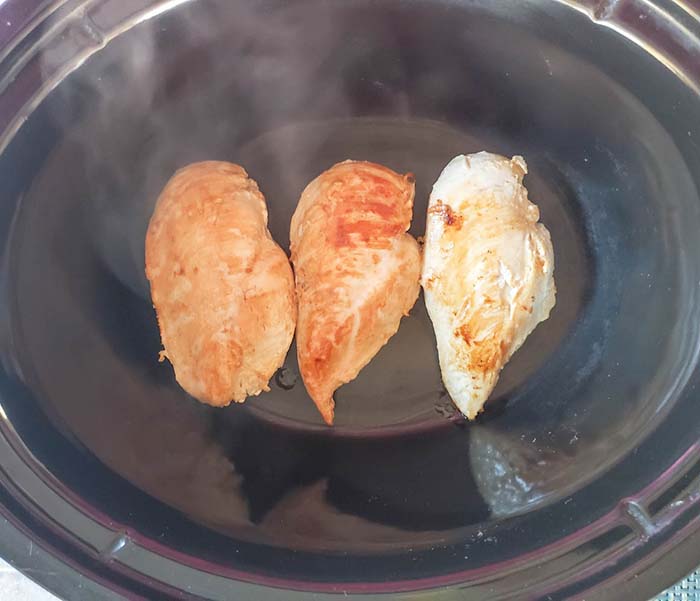 three chicken breasts in a slow cooker