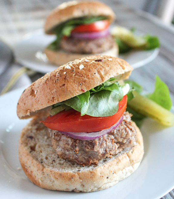 chicken burger on a roll with lettuce tomato and onion