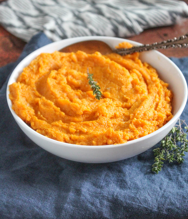 Mashed sweet potatoes in a bowl with a spoon