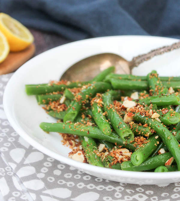 a close up picture of green beans with crispy topping 