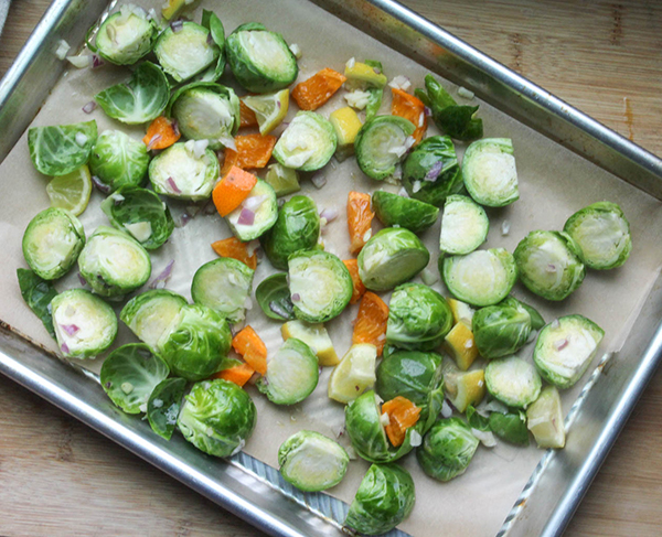 brussels sprouts and citrus pieces on a baking sheet