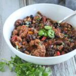 a bowl of turkey chili with a spoon in it with jalapeno slices on top