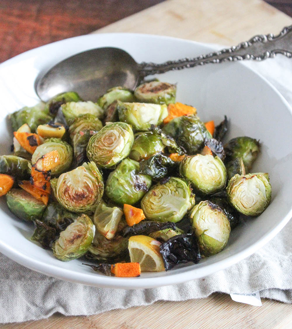 The finished product roasted brussels sprouts in a bowl with a serving spoon