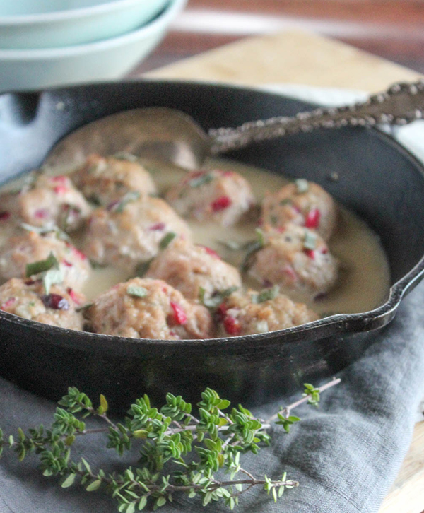 Turkey meatballs in gravy in a pan with a serving spoon