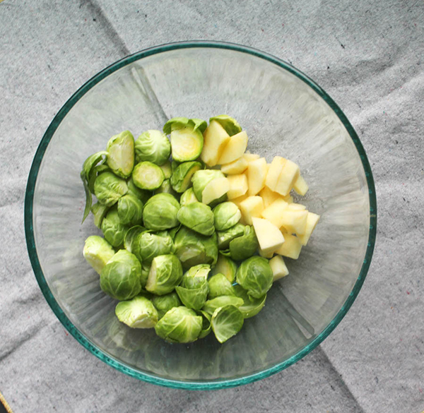 apples and brussels sprouts in a mixing bowl