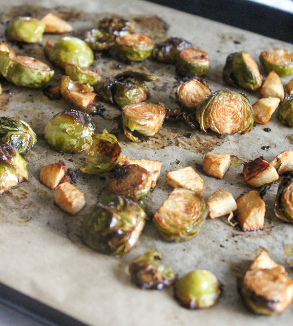 Roasted Brussels sprouts with apples on a baking sheet